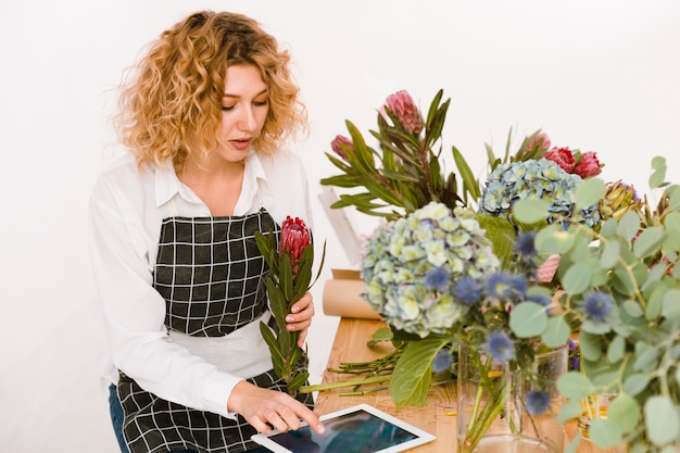 Medium shot woman typing something on tablet