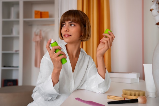 Free photo medium shot woman using dry shampoo at home