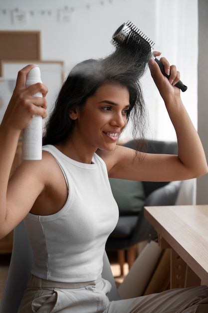 Medium shot woman using dry shampoo at home