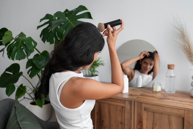 Free photo medium shot woman using dry shampoo at home