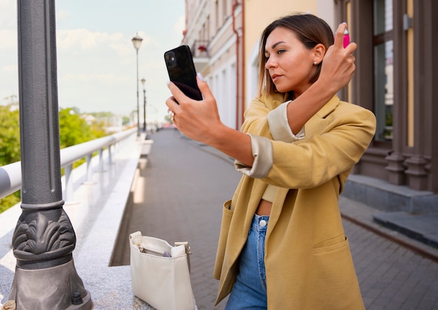 Medium shot woman using dry shampoo outdoors