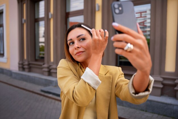 Medium shot woman using dry shampoo outdoors