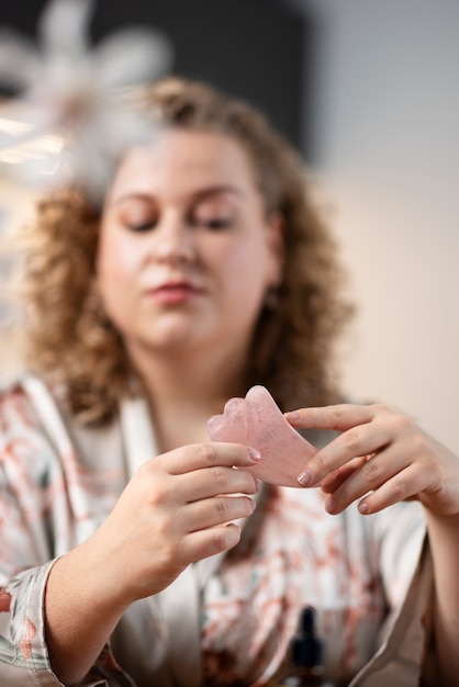 Free Photo medium shot woman using gua sha tool