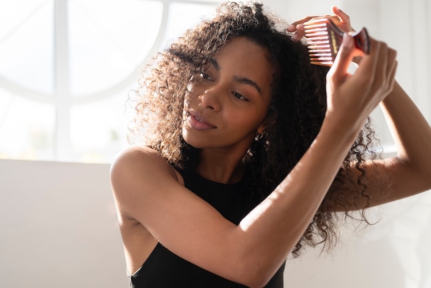 Medium shot woman using hair comb