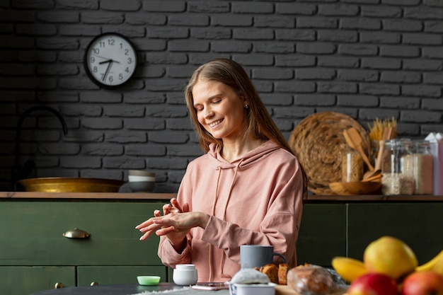 Free photo medium shot woman using hand cream