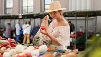 Free photo medium shot woman using organic bag for veggies