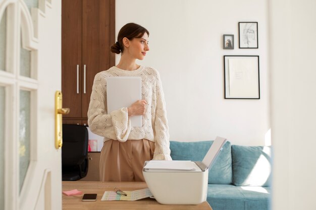 Medium shot woman using printer at work