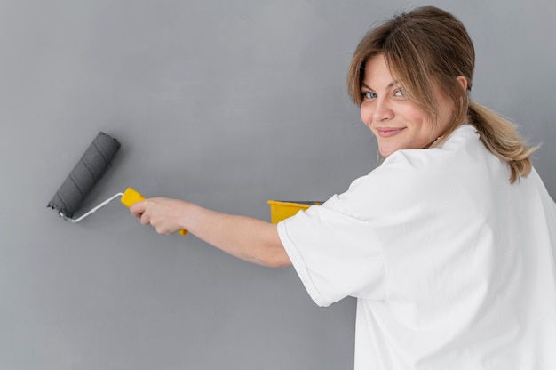 Medium shot woman using roller