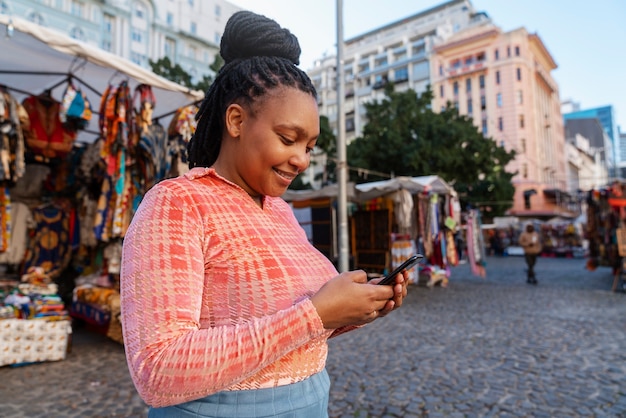 Medium shot woman using smartphone outdoors