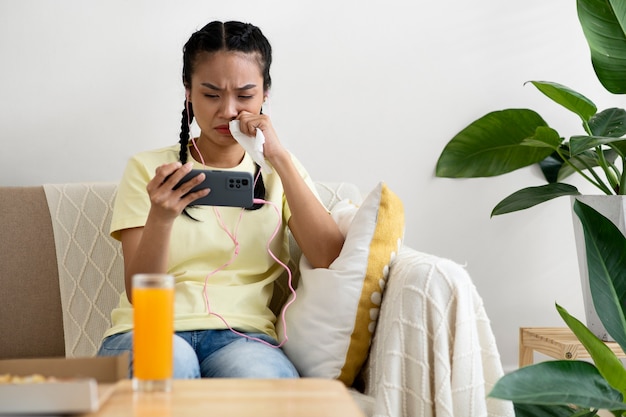 Medium shot woman watching movie on phone