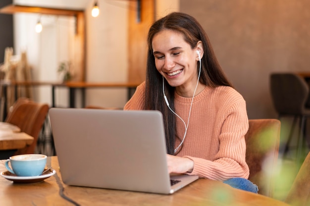 Medium shot woman wearing earphones