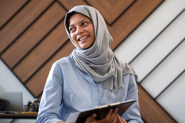 Medium shot woman wearing hijab at work