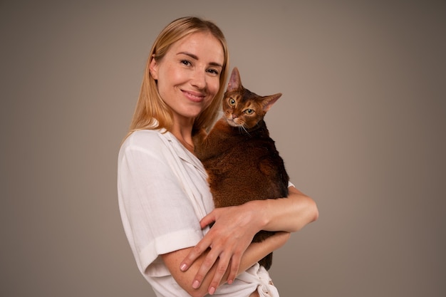 Free photo medium shot woman with cat in studio