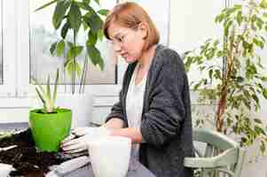 Free photo medium shot woman with gloves gardening