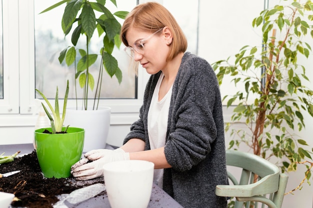 Free Photo medium shot woman with gloves gardening