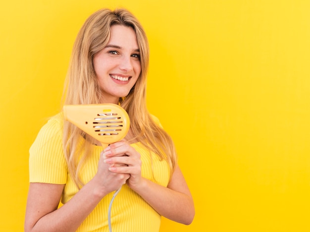 Medium shot woman with hair dryer