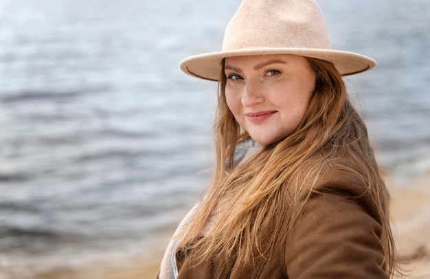 Free photo medium shot woman with hat at seaside