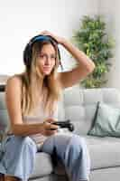 Free photo medium shot woman with headphones on couch