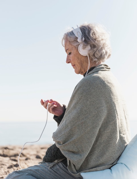 Medium shot woman with headphones outdoors