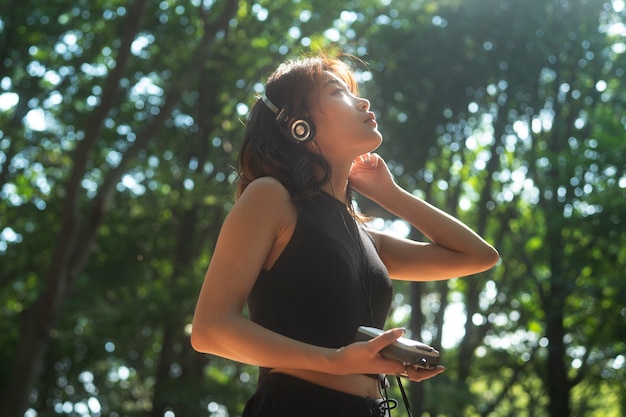 Medium shot woman with headphones outdoors