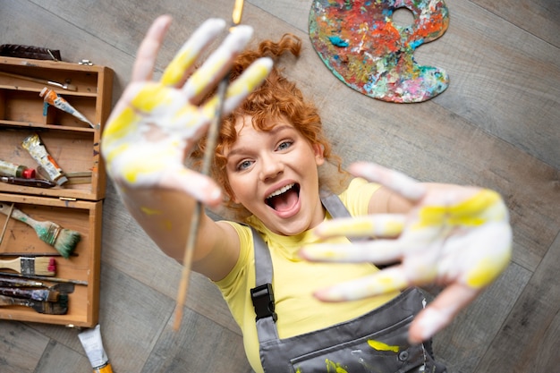 Medium shot woman with paint on hands