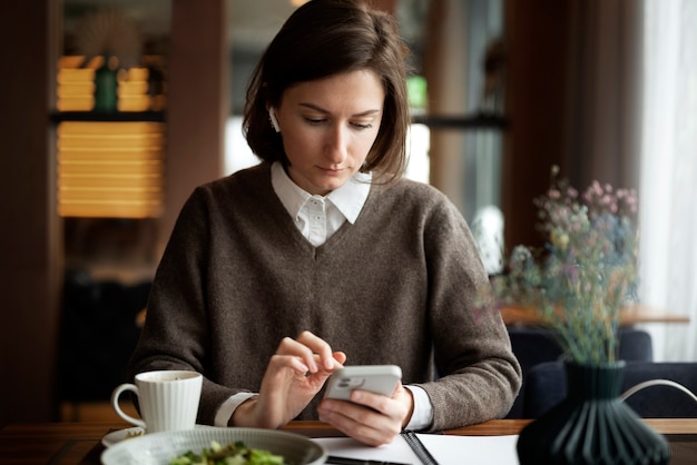 Medium shot woman with smartphone