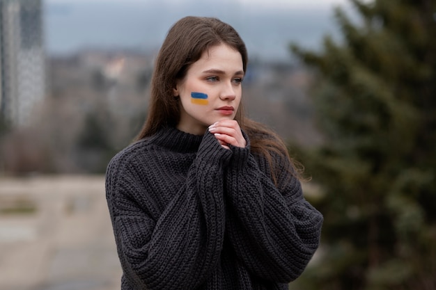 Free Photo medium shot woman with ukranian flag drawing