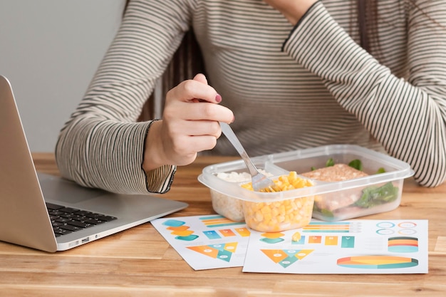 Free photo medium shot of woman working and eating