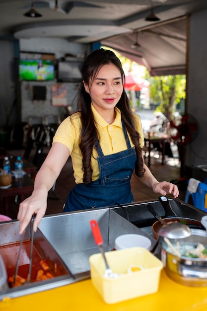 Medium shot woman working at food truck