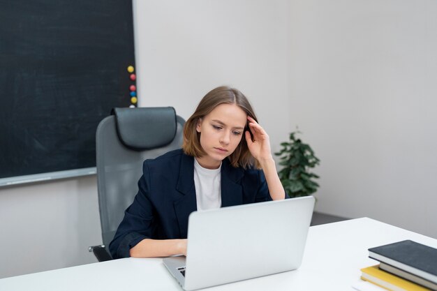 Medium shot woman working on laptop