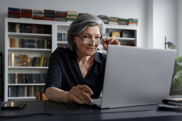 Medium shot woman working on laptop