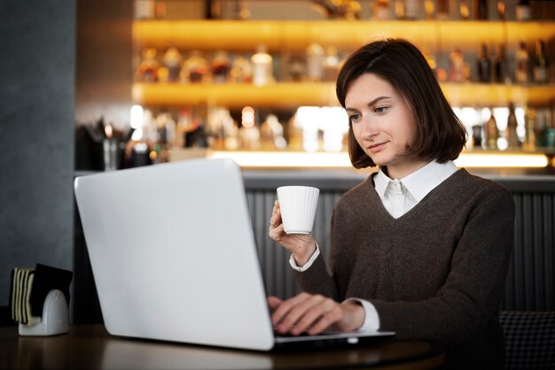 Medium shot woman working on laptop