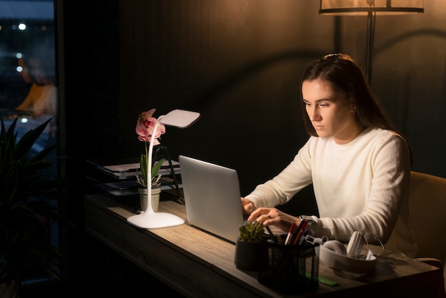 Medium shot woman working late at night