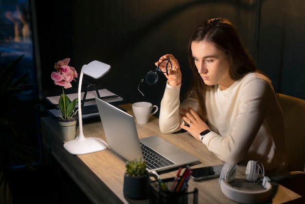 Medium shot woman working late at night