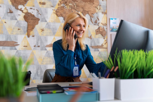 Free Photo medium shot woman working in the office of a travel agency