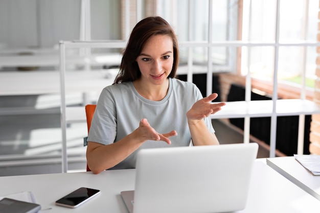 Medium shot woman working with laptop