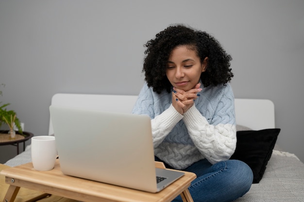 Medium shot woman working with laptop