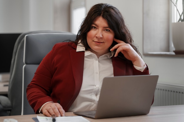 Medium shot woman working with laptop