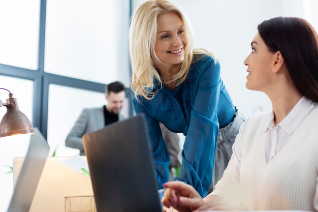 Free photo medium shot women chatting at work