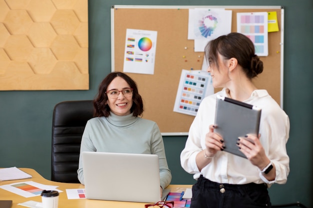 Medium shot women chatting at work