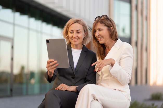 Medium shot women holding tablet