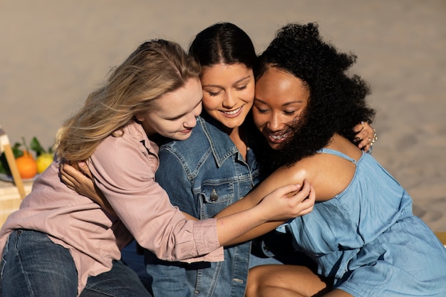 Medium shot women hugging at beach