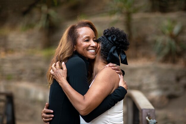 Medium shot women hugging in nature