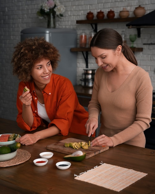 Free photo medium shot women learning to make sushi