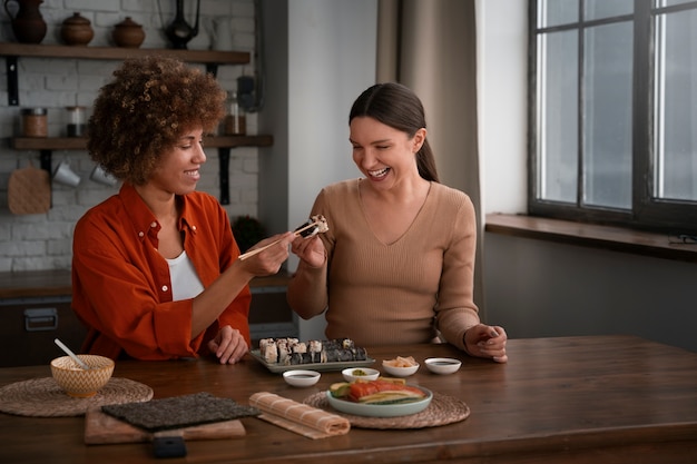 Medium shot women learning to make sushi