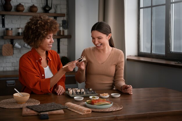 Medium shot women learning to make sushi