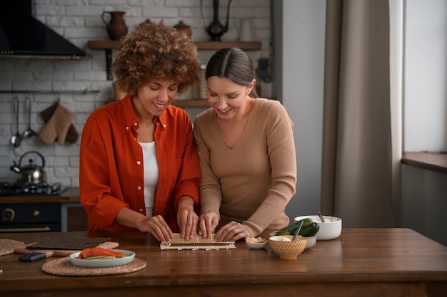 Free photo medium shot women learning to make sushi