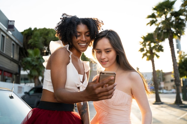 Medium shot women looking at phone