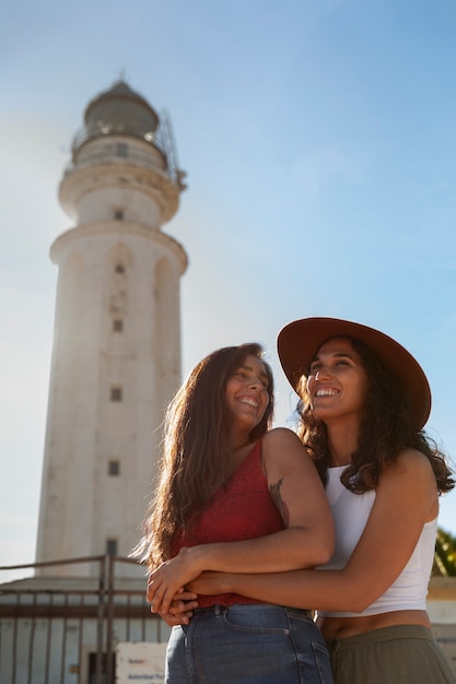 Medium shot women posing with lighthouse