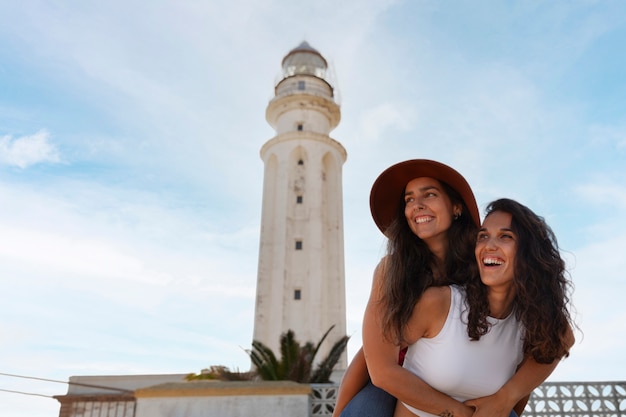 Medium shot women posing with lighthouse